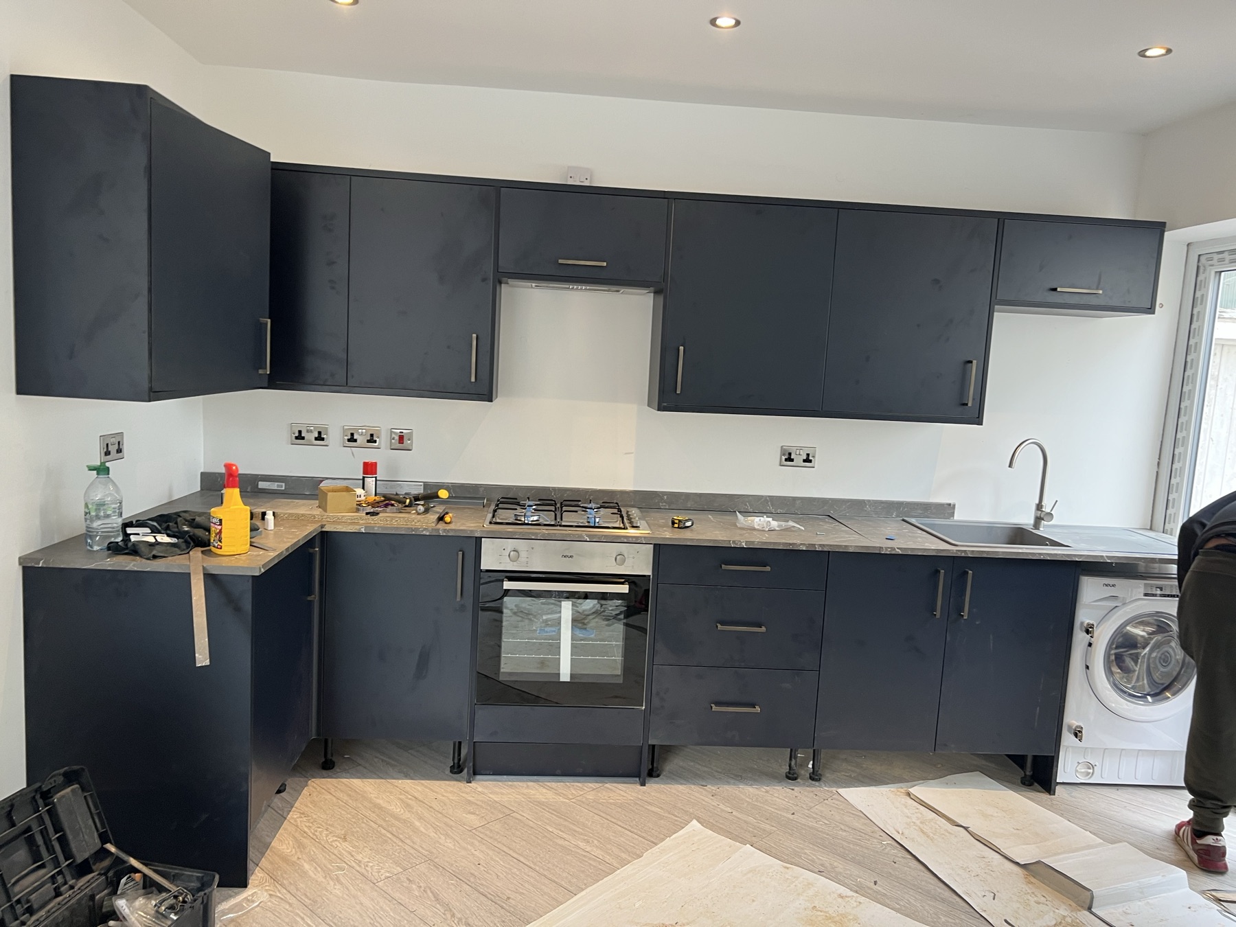 Completed kitchen installation with integrated appliances and new flooring