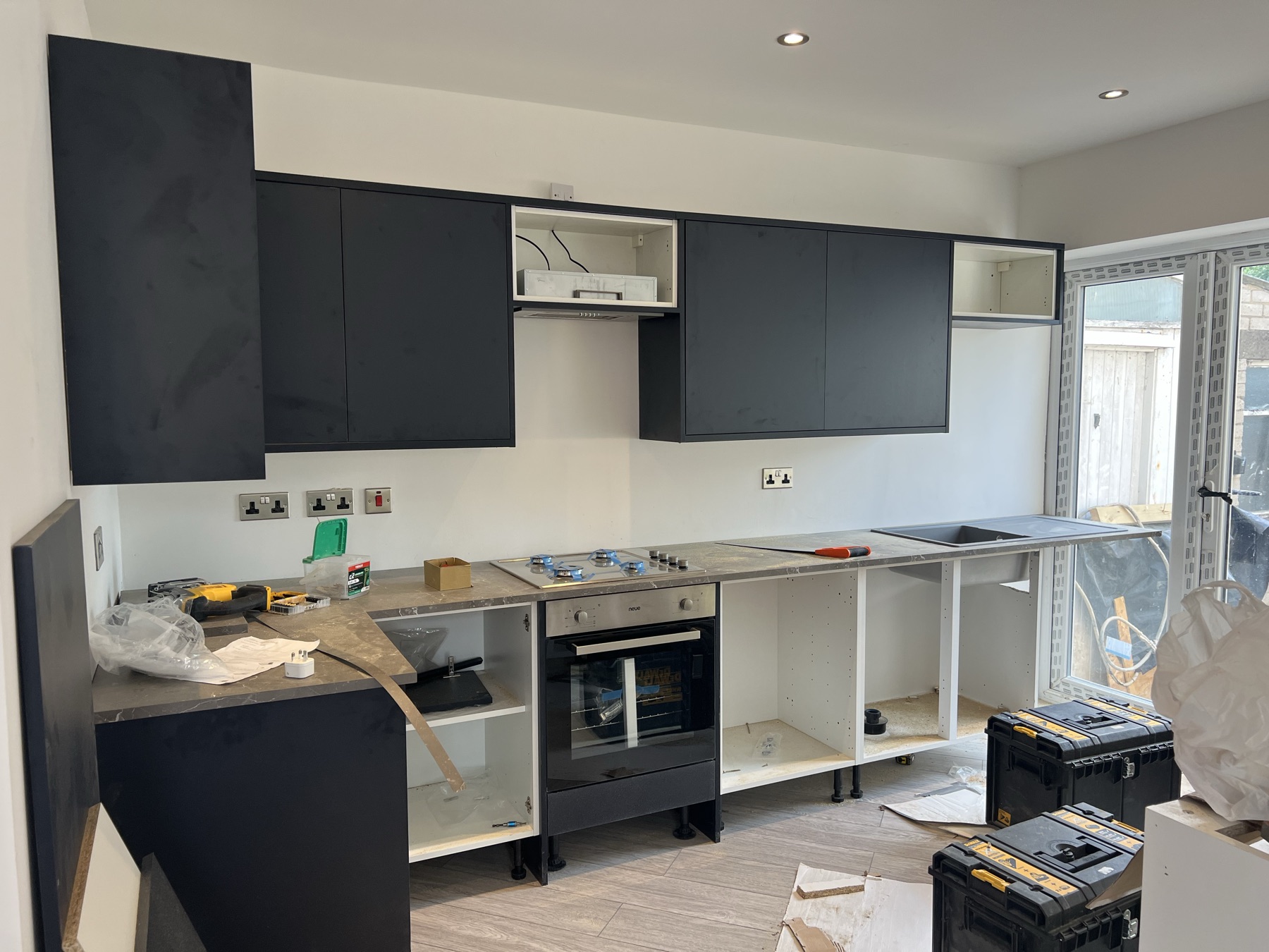 New kitchen units being installed, with worktop, hob and sink fitted