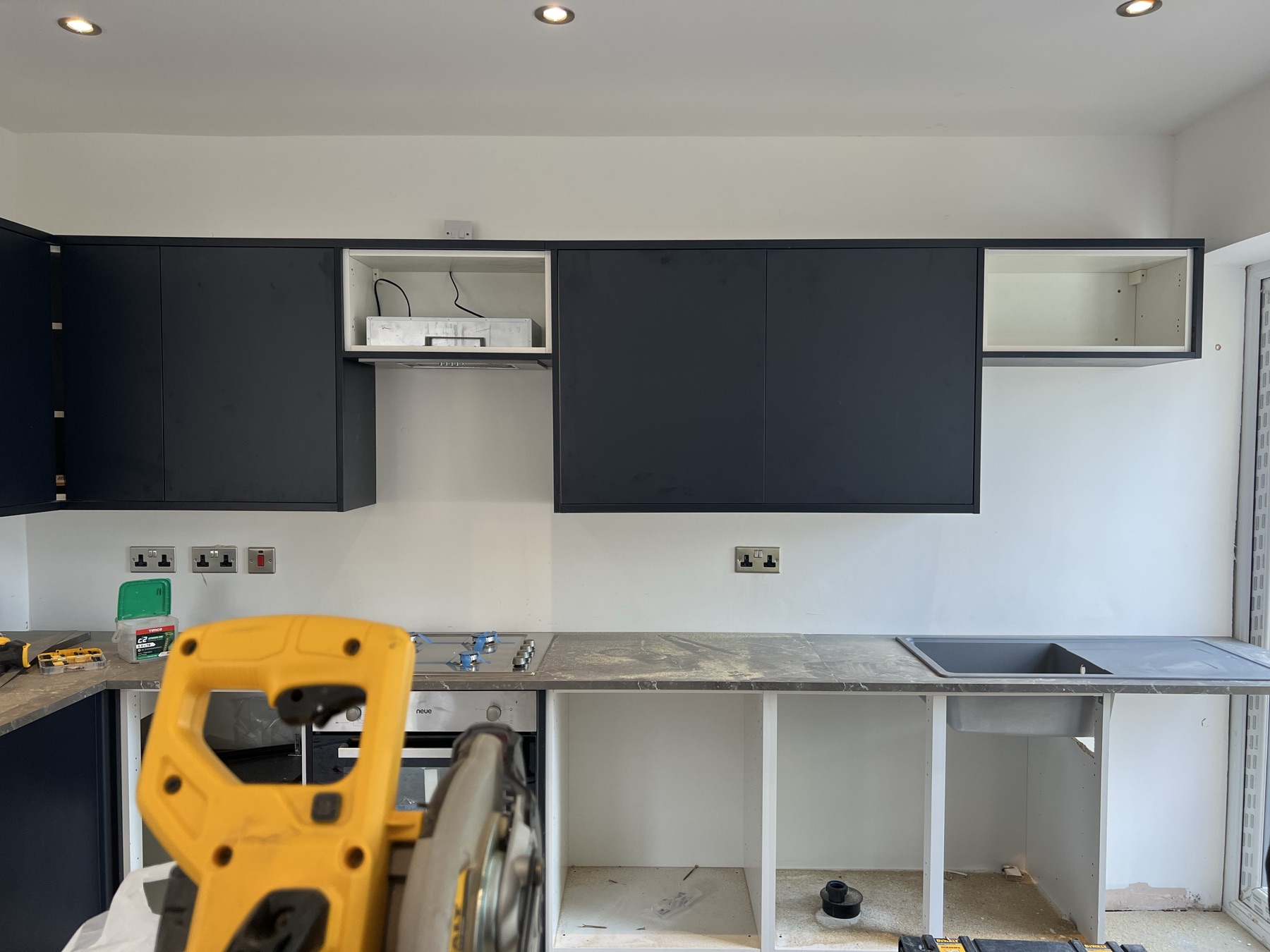 New kitchen wall units and extractor being installed
