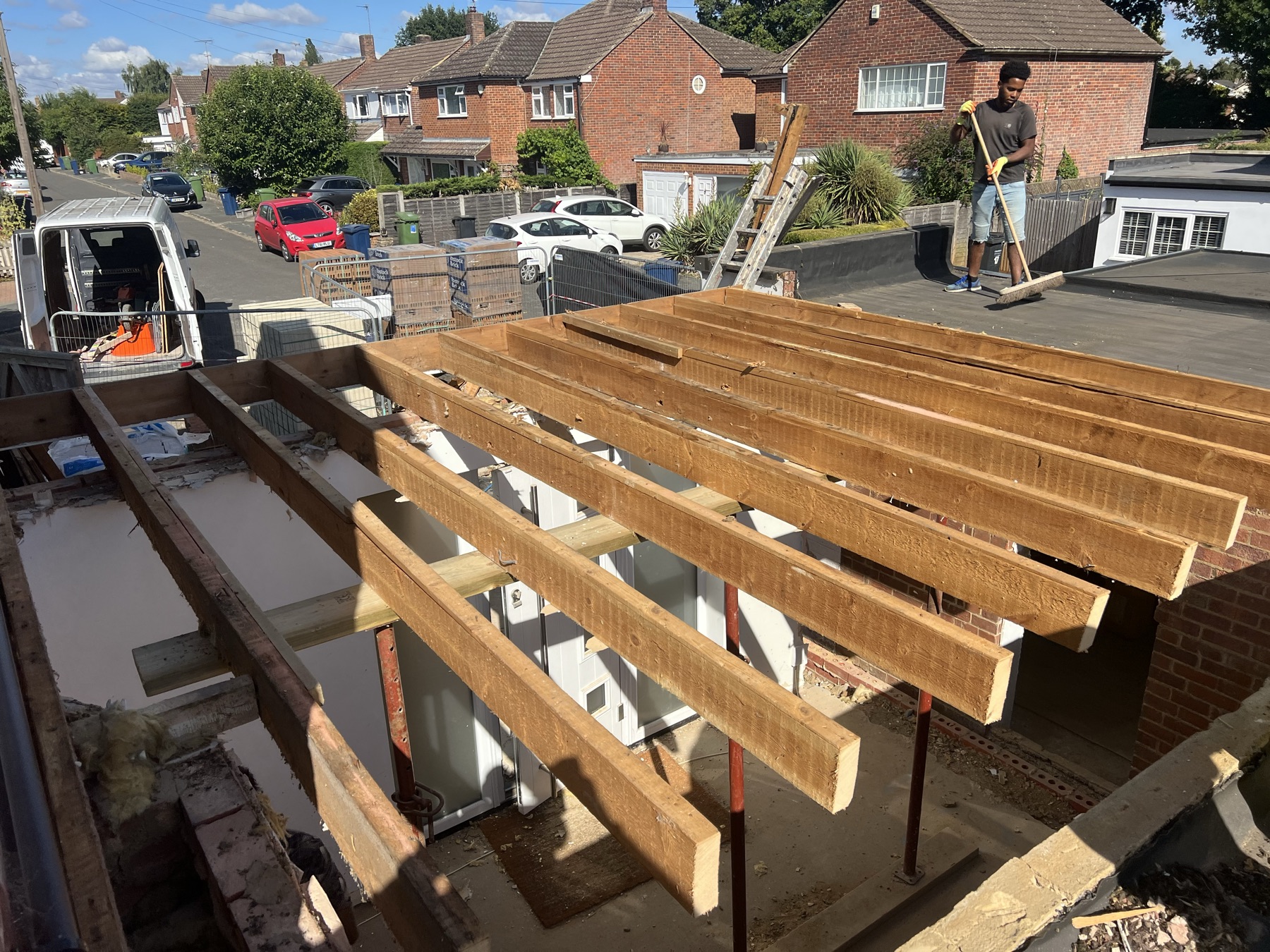 Flat roof structure of the single storey portion being felted, overlooking the street