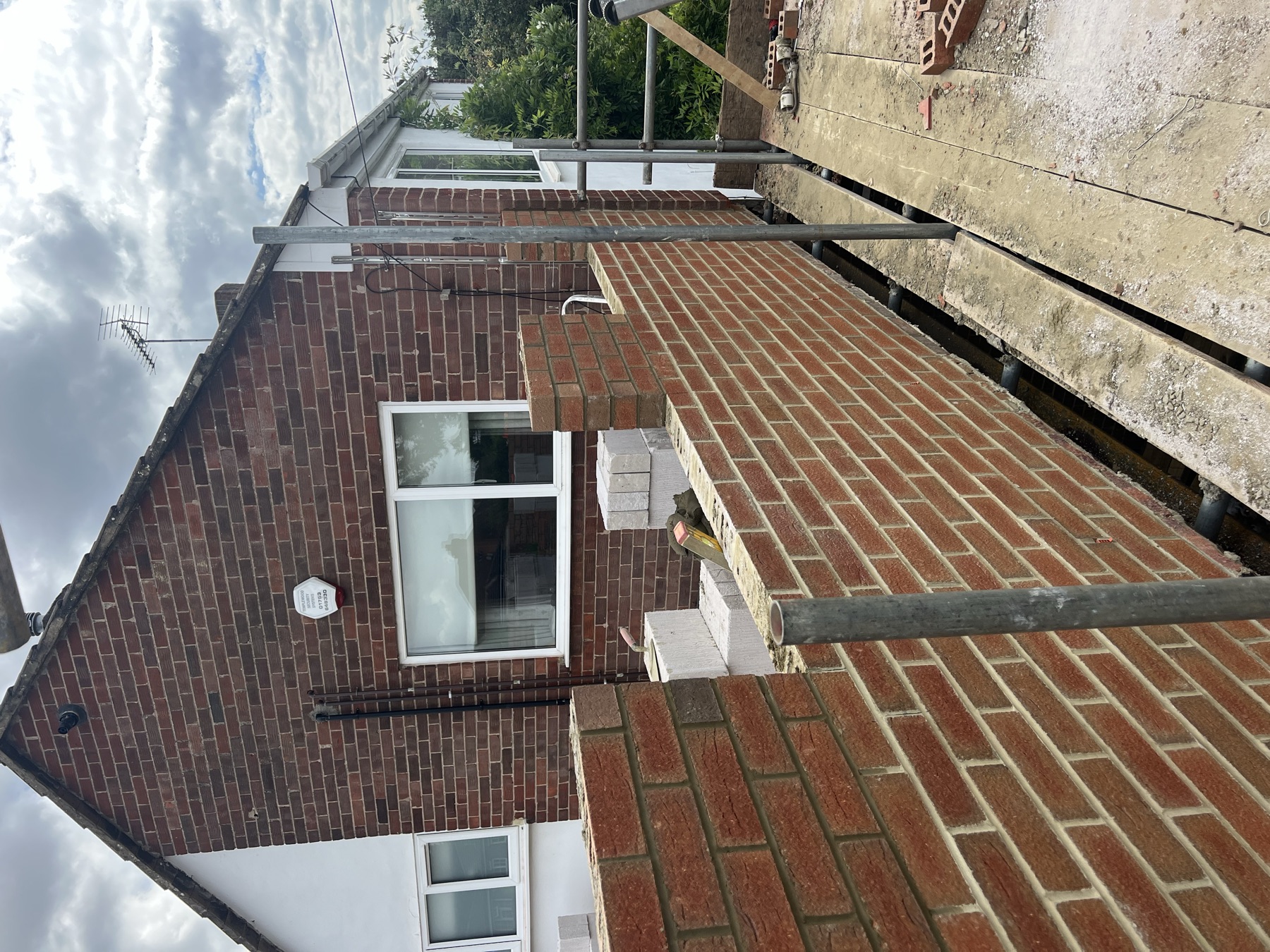 New brickwork to the side extension built up towards eaves level, matched to the existing house