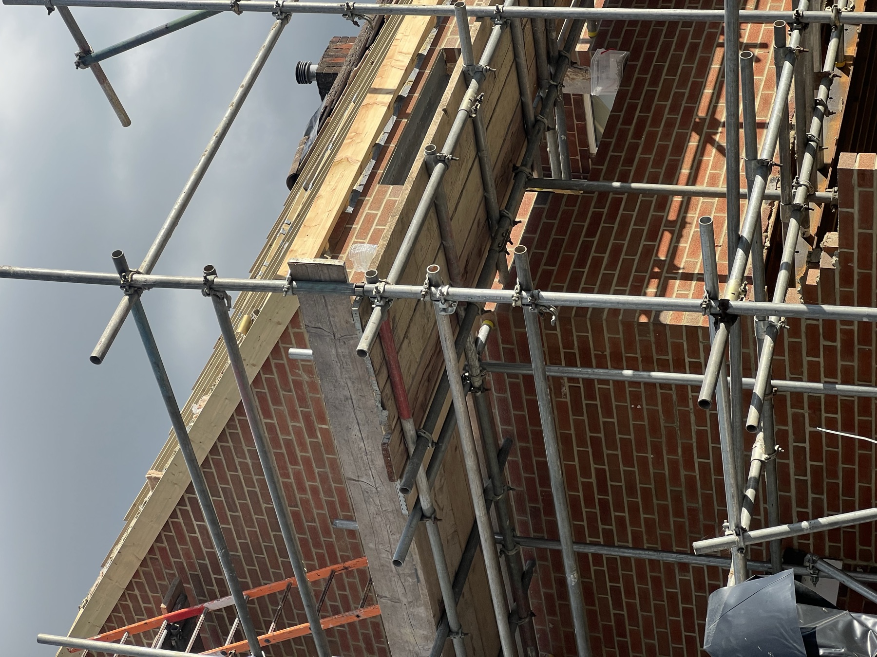 First floor brickwork nearing eaves level with scaffold boarding for access