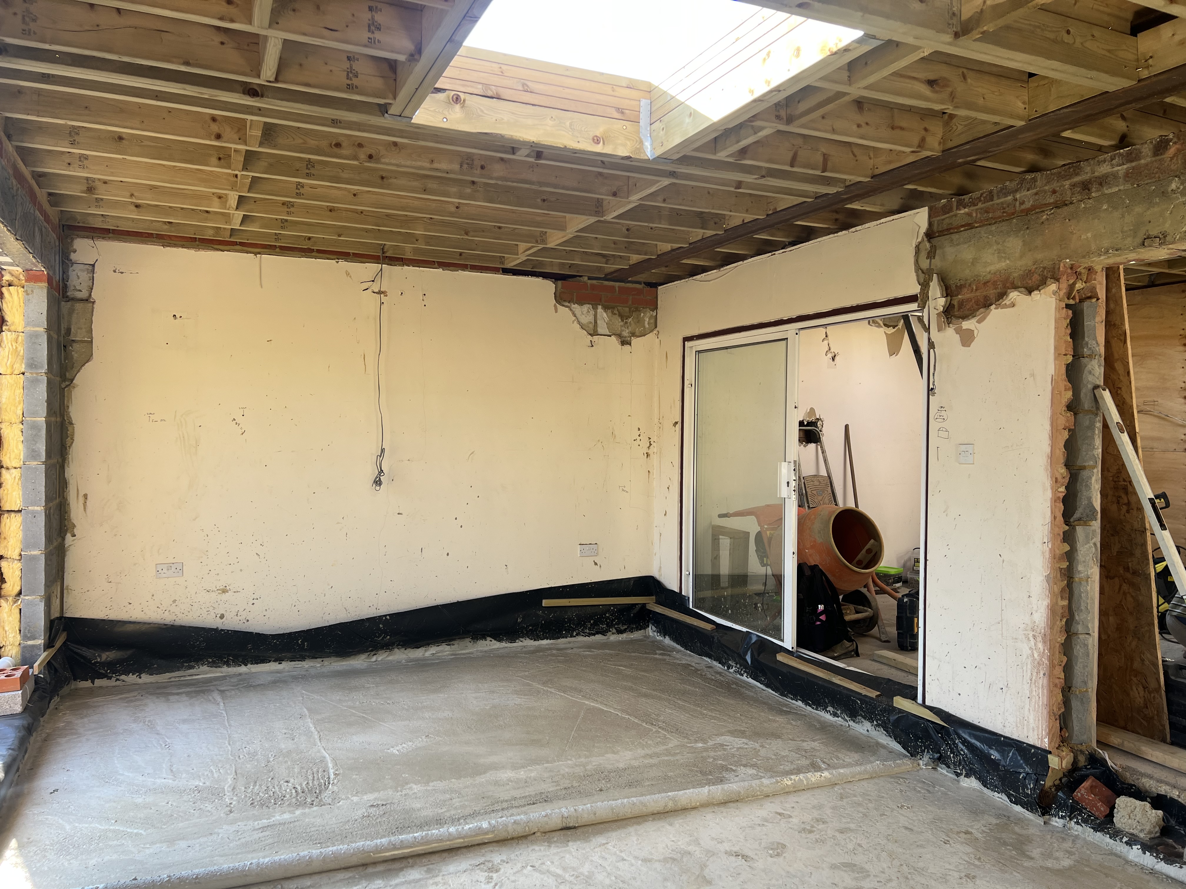 Interior of the new extension's structural shell, showing blockwork walls and roof joists before internal finishes