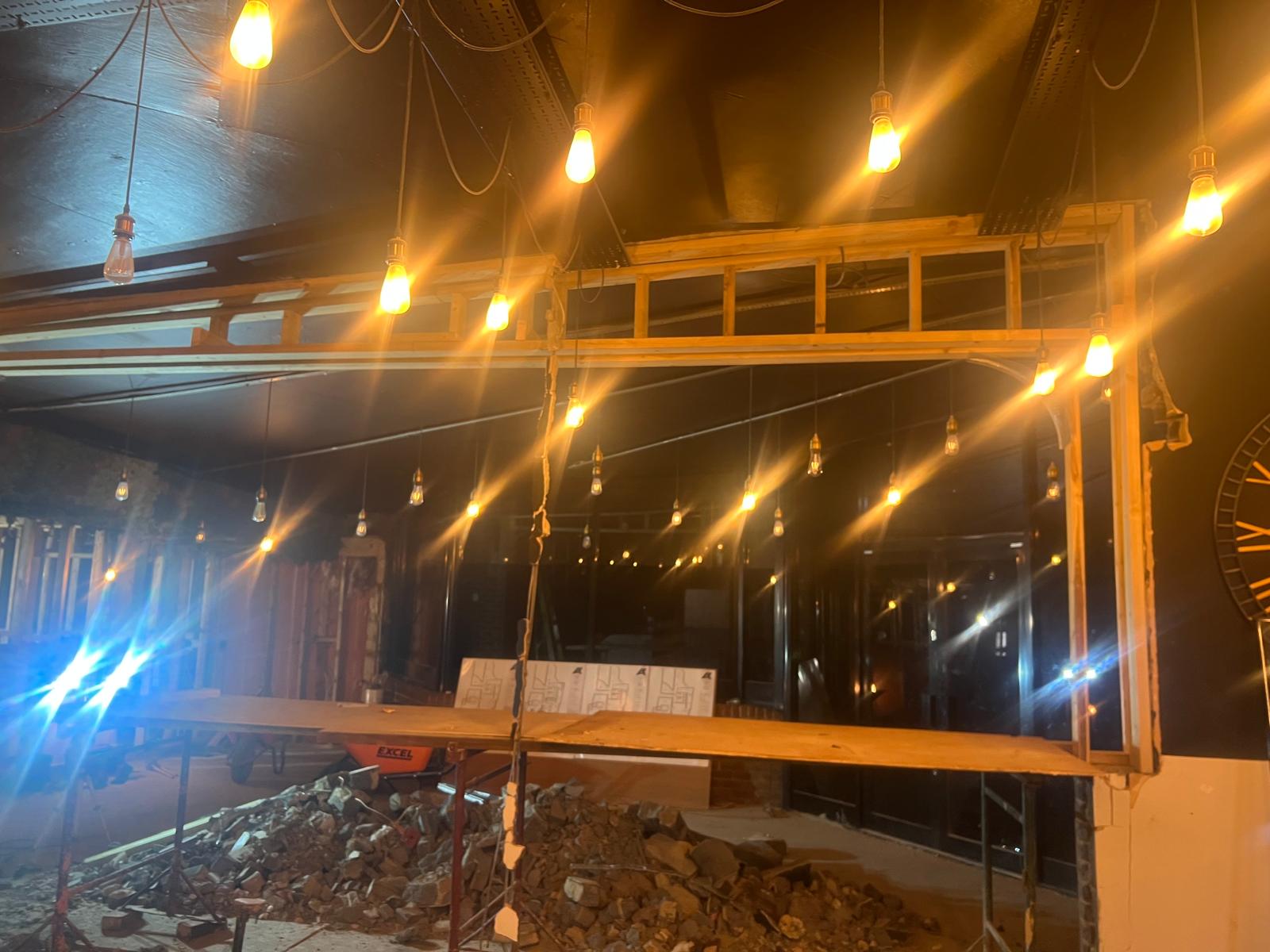 Tradesmen installing a large feature light fixture from a scissor lift