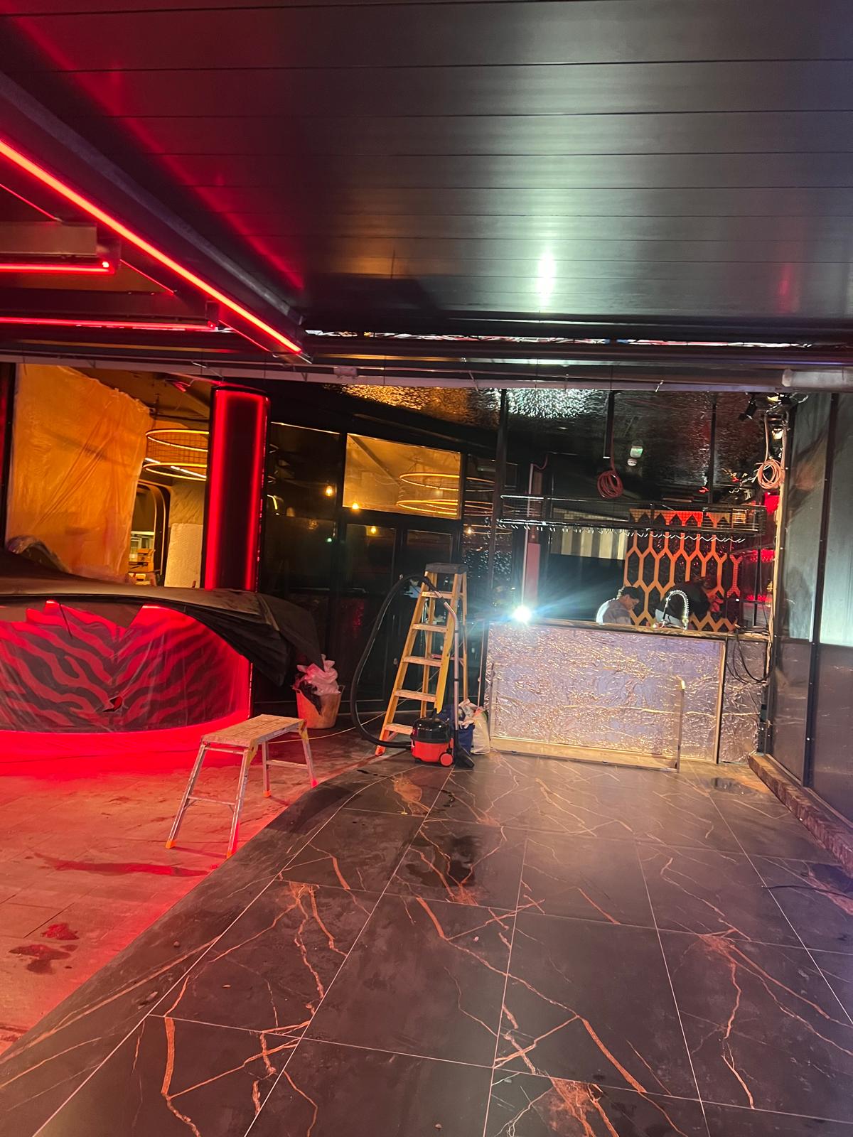 The bar and lounge area lit at night, nearing completion