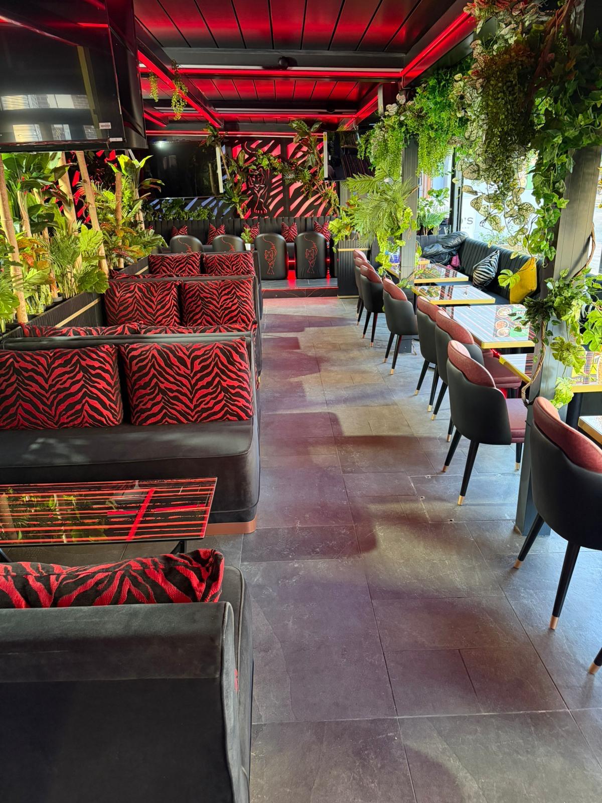 Completed lounge seating area in daylight, with zebra-print cushions and dining tables set