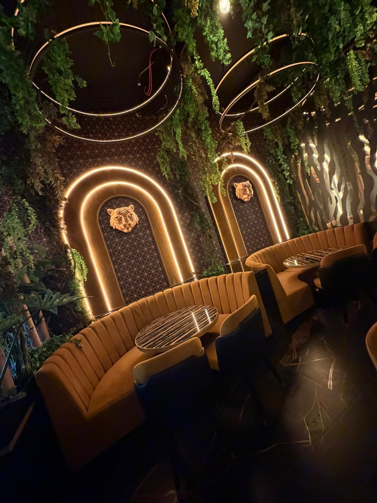 Completed booth seating nook beneath a gold arch with a tiger wall feature